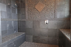 Stone tiled and pebble stone tiles features on walls and floor of walk in shower